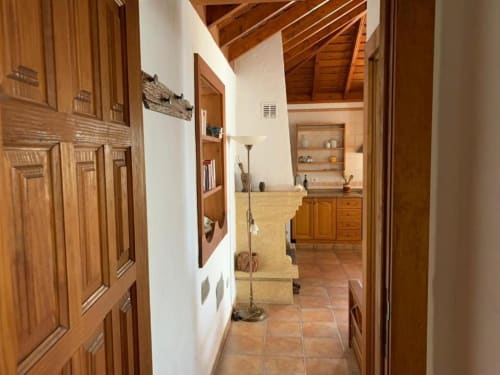 Pasillo de madera en casa rural Villa El Topo con piso de terracota y almacenamiento empotrado
