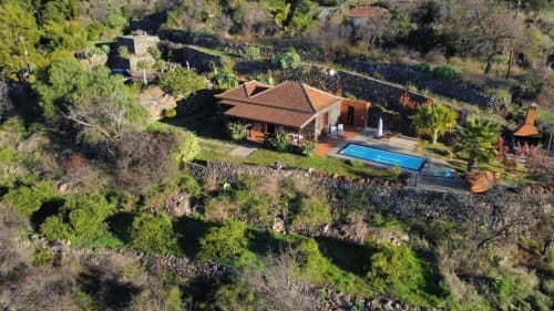 Vista aérea de Villa El Topo, villa con tejado de barro en El Pinillo, piscina privada rodeada de exuberante vegetación mediterránea