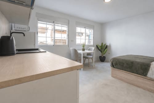 Estudio luminoso en Studios Sanchis, Alicante con cocina, cama, comedor y vistas a la ciudad