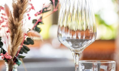 Elegant wine glass with pink flowers at Hôtel Restaurant Le S'Y in Seingbouse, France