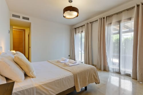 Spacious bedroom at Ayma Villa Cielo y Mar in Benalmádena with queen bed, terrace doors, and modern amenities