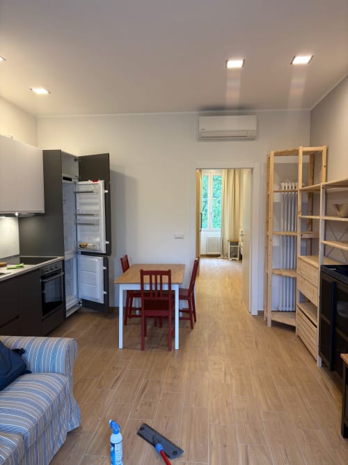 Moderno appartamento a Milano con cucina open space, zona pranzo, pavimenti in legno e arredamento contemporaneo