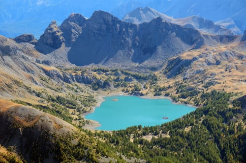 Lac alpin turquoise entouré de montagnes et forêts près de Meolans-Revel, France