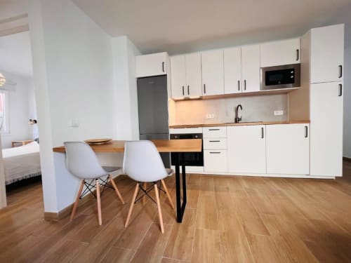 Cocina y comedor modernos en El HierroStay Apartments, La Restinga con muebles blancos, encimeras de madera y vistas de la ciudad