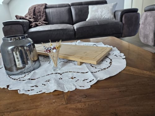 Séjour élégant du Cap à l'Ouest avec canapé noir, table basse en bois et tapis blanc en dentelle