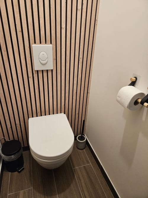 Toilettes modernes avec abattant à fermeture progressive dans l'appartement Cap à l'Ouest au Clos De La Côte D'émeraude, Saint-Benoît-des-Ondes,