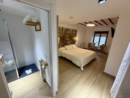 Modern bedroom in Almagro with queen bed, wooden floors, en-suite bathroom, and city views at Complejo Turístico Retiro del