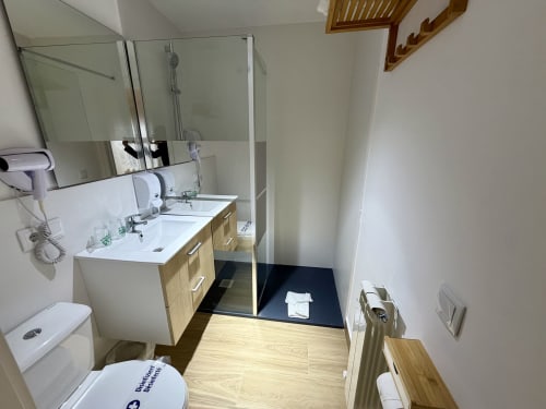 Modern bathroom with double vanity, glass shower enclosure, and wooden finishes at Complejo Turístico Retiro del Teatro,