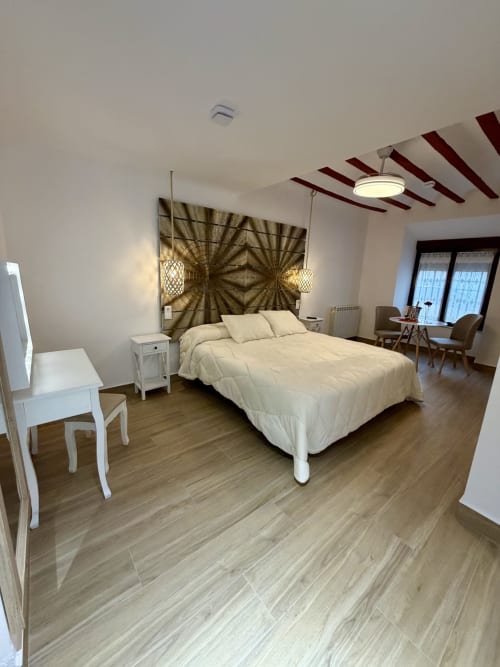 Modern bedroom at Retiro del Teatro with queen bed, white furniture, and wooden flooring in Almagro, Ciudad Real