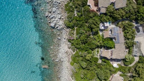 Vista aerea di Villa Marilin in Sardegna con mare turchese, costa rocciosa, accesso spiaggia privata e villa mediterranea