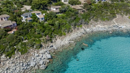 Vista aerea di Villa Marilin a Quartu Sant'Elena, Sardegna con mare turchese, costa rocciosa e accesso spiaggia privata