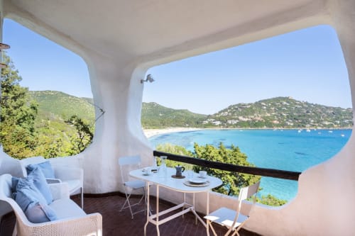 Terrazza di villa costiera in Sardegna con vista sul mare, arredamento bianco e acque blu turchese del Mediterraneo