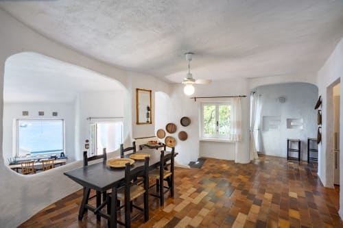 Sala da pranzo spaziosa con vista sul mare, pavimenti in cotto e arredi tradizionali a Top Villas Sardegna, Quartu