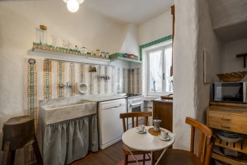 Cucina rustica a Top Villas Sardegna con tradizionale rivestimento piastrellato, lavello in stile fattoria e zona pranzo a Quartu Sant'Elena