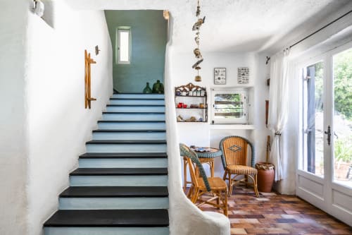Ingresso mediterraneo con scale blu, sedie in rattan e piastrelle in terracotta a Top Villas Sardegna