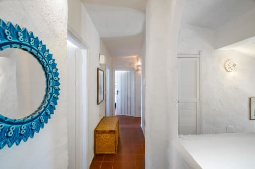 Corridoio di villa moderna a Quartu Sant'Elena con specchio decorativo turchese e pavimentazione in cotto