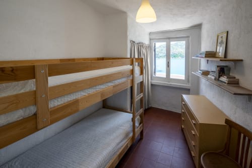 Letto a castello in legno in camera luminosa presso Top Villas Sardegna con vista mare e servizi moderni