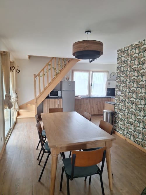 Dining area with wooden table and chairs in Gîte Kerroc'h cottage at Le Village Du Moulin, Sizun, with open kitchen and