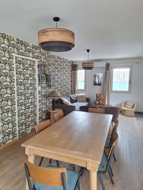 Dining area in Gîte Kerroc'h cottage at Le Village Du Moulin, Sizun with wooden table, patterned wallpaper, and pendant