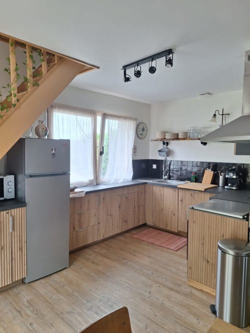 Modern kitchen in Gîte Kerroc'h cottage at Le Village Du Moulin, Sizun with wood cabinets and stainless steel appliances
