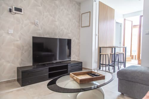 Salon moderne d'un appartement avec télévision et accès à un patio avec vue sur le jardin à La Valette du Var, France
