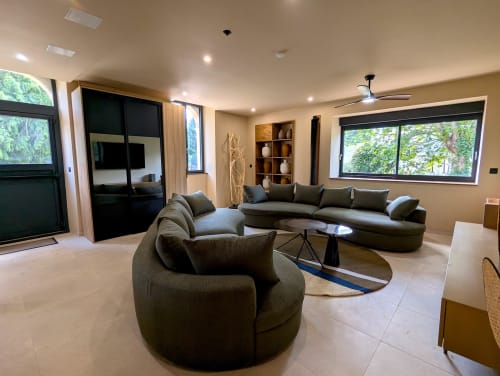 Salon moderne au Domaine Alga avec canapé arrondi, fauteuil et vue sur la campagne de Bourg-Charente