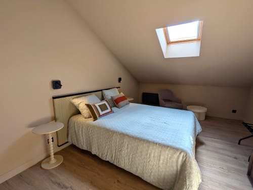 Chambre mansardée lumineuse au Domaine Alga avec puits de lumière, lit queen et mobilier moderne à Bourg-Charente