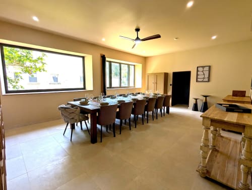 Elegant dining room at Domaine Alga B&B in Bourg-Charente with long table, modern ceiling fan, and natural light