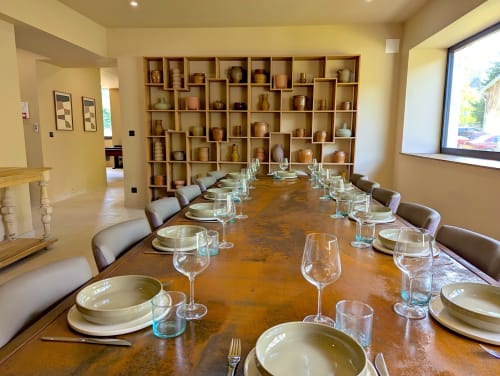 Élégante salle à manger du Domaine Alga B&B à Bourg-Charente avec table conviviale, couverts et étagère de poteries