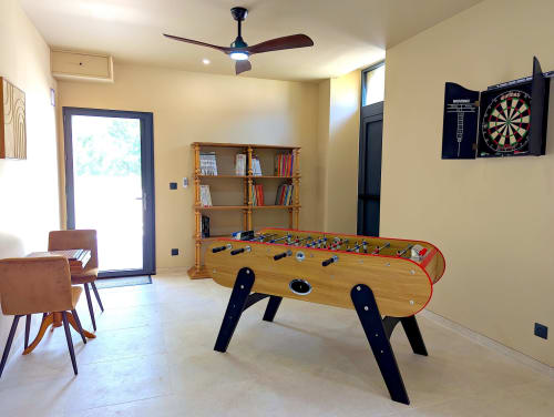 Salle de jeux au Domaine Alga avec baby-foot, fléchettes, bibliothèque et ventilateur de plafond