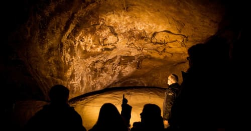 Visite des peintures rupestres du Prat de Lacout en Ariège avec des visiteurs explorant l'art préhistorique