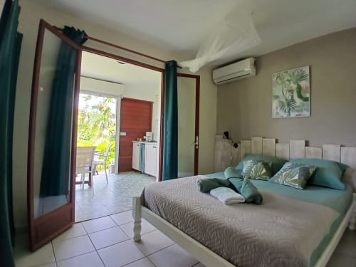 Studio bedroom at Ti Village Créole in Sainte-Anne with queen bed, garden view, AC, and kitchenette access