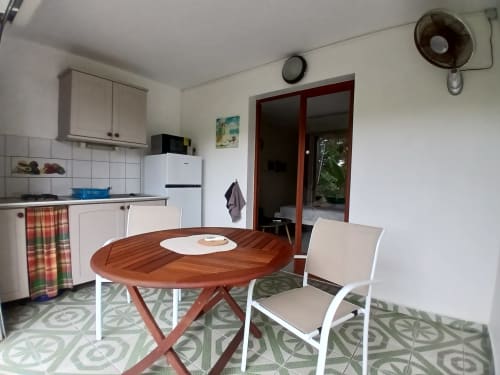Studio apartment at Ti Village Créole with dining table, kitchen, and garden view in Sainte-Anne, Guadeloupe