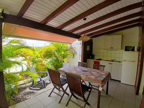 Ti Village Créole bungalow in Sainte-Anne with open-air dining, equipped kitchen, and tropical garden view