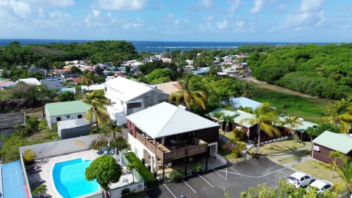 Aerial view of Ti Village Créole bungalows with pool in tropical garden setting, Sainte-Anne Guadeloupe