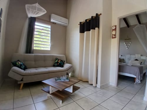 Living area in bungalow at Ti Village Créole, Sainte-Anne with sofa, coffee table, and bedroom view