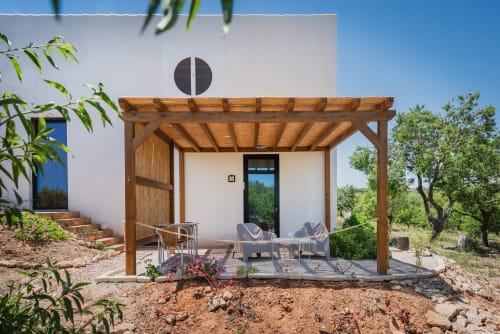 Pátio moderno com pérgola de madeira e espreguiçadeiras na pousada Monte das Açoteias, Tavira