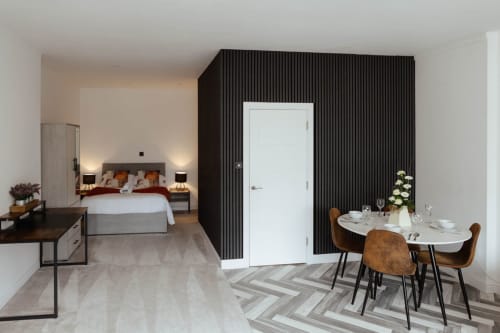 Spacious modern apartment suite at JS Apartments Collection in Blackburn with bedroom, dining area, and black feature wall