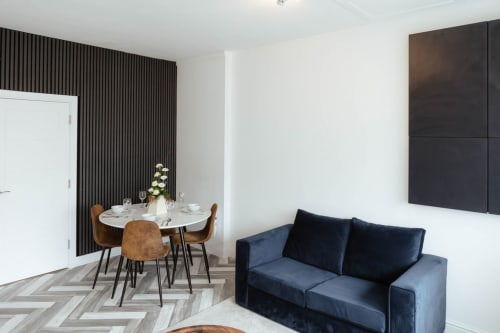 The Spacious Suite at JS Apartments, Blackburn: modern living area with navy sofa, round dining table, and city views