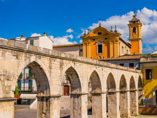 Antico acquedotto in pietra con chiesa dorata a Sulmona, Italia vicino all'Hotel Almatros