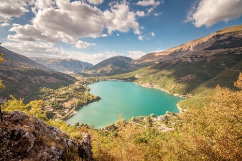 Lago alpino turchese circondato da montagne boscose vicino a Sulmona, meta turistica italiana