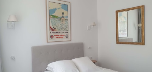 Chambre confortable aux Cabines à Houlgate avec tête de lit capitonnée grise, oreillers blancs et décor nautique vintage