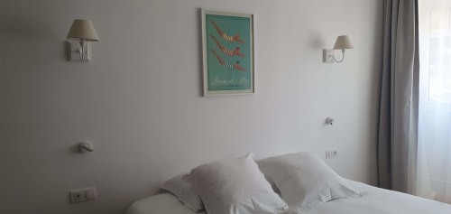 Chambre moderne de l'hôtel Les Cabines à Houlgate avec literie blanche, appliques murales et décoration thème côtier