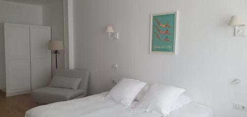 Chambre lumineuse à l'hôtel Les Cabines à Houlgate avec lits jumeaux, armoire et affiche vue sur la ville