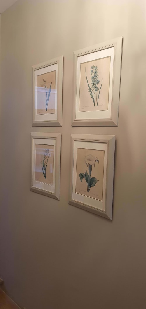 Quatre illustrations botaniques encadrées de fleurs et plantes sur mur crème dans une chambre de l'hôtel Les Cabines, Houlgate