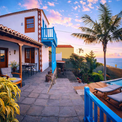 Apartamento La Gorona en Rural La Palma con terraza, barandillas azules, vistas al océano y palmeras al atardecer