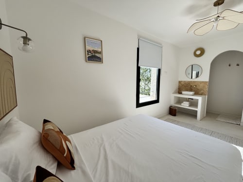 Chambre moderne à Domaine Mas Lafleur à Châteaurenard avec lit blanc, salle de bain attenante et miroir arqué
