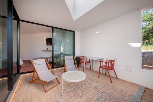 Modern studio apartment terrace at Monte das Açoteias with seating, dining table, and garden views in Tavira