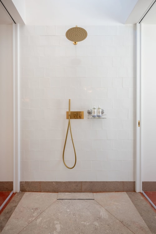 Modern bathroom shower with brass fixtures and rainfall showerhead in Tavira, Portugal boutique guesthouse