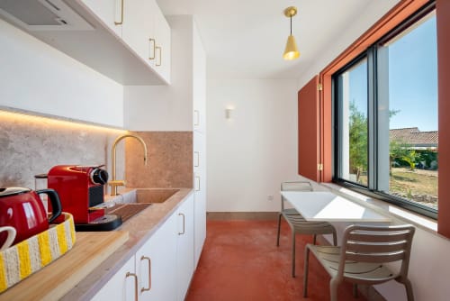 Modern studio kitchenette at Monte das Açoteias with red coffee machine, white cabinetry, dining area by large windows